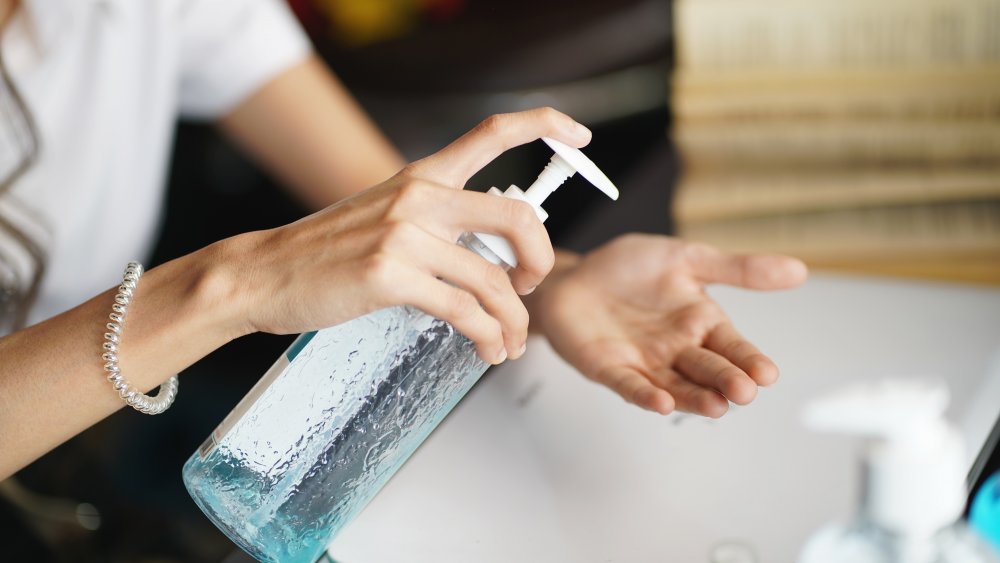 A woman's hands holding a bottle of hand sanitizer