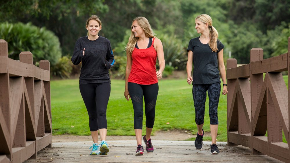 Three blonde women walking on a path