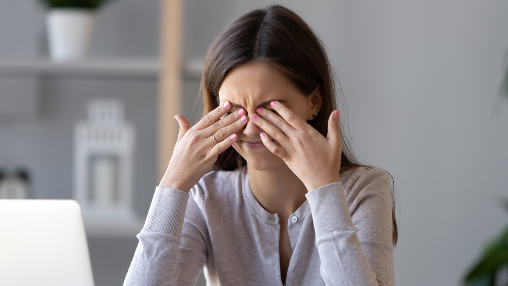 A woman rubbing her eyes