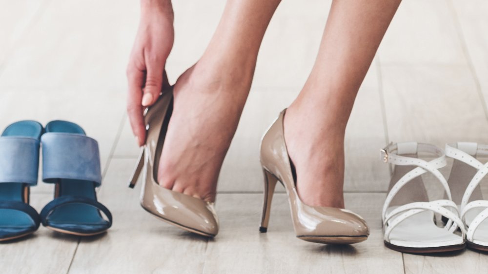a woman putting heels on