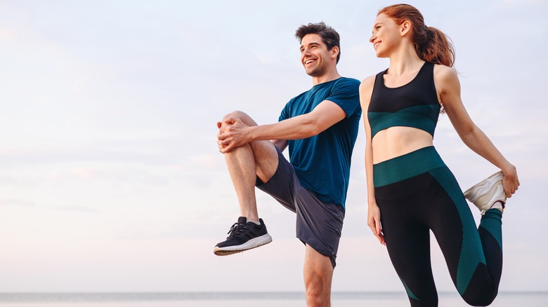 active and healthy couple stretching