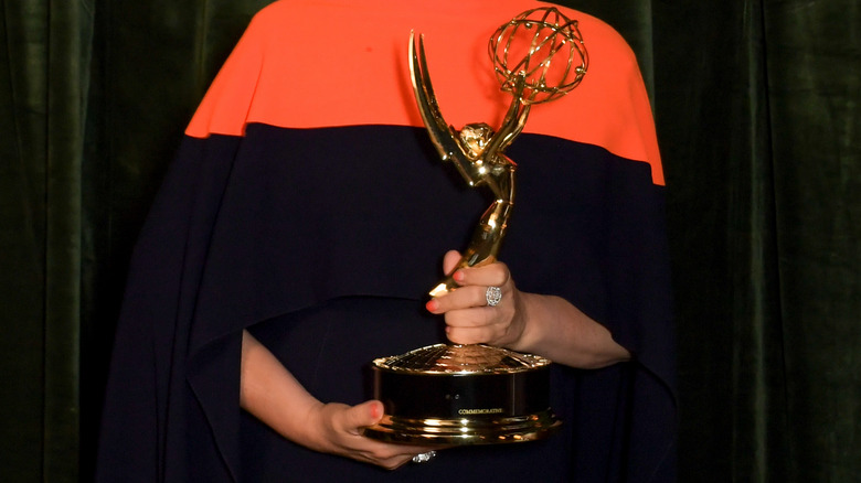 Black woman holding Emmy award