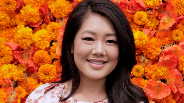 Crystal Minkoff smiling in front of flower wall