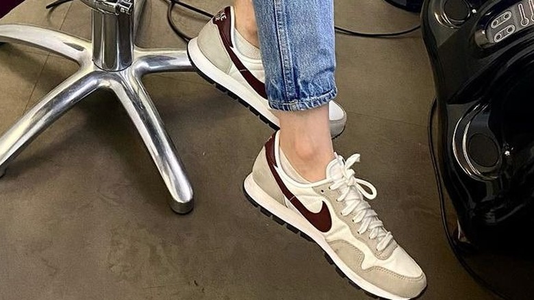 Lily Collins with Ashley Park wearing her Nike sneakers 