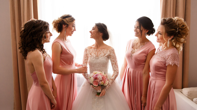 A bride with long sleeve dress and bridesmaids