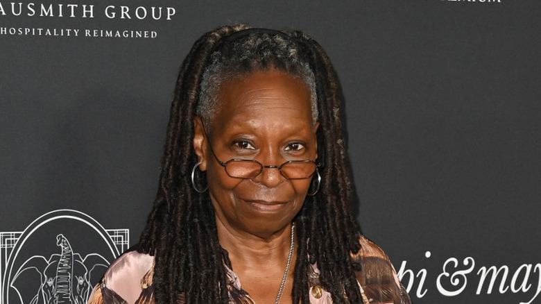 Whoopi Goldberg posing at an event while wearing glasses