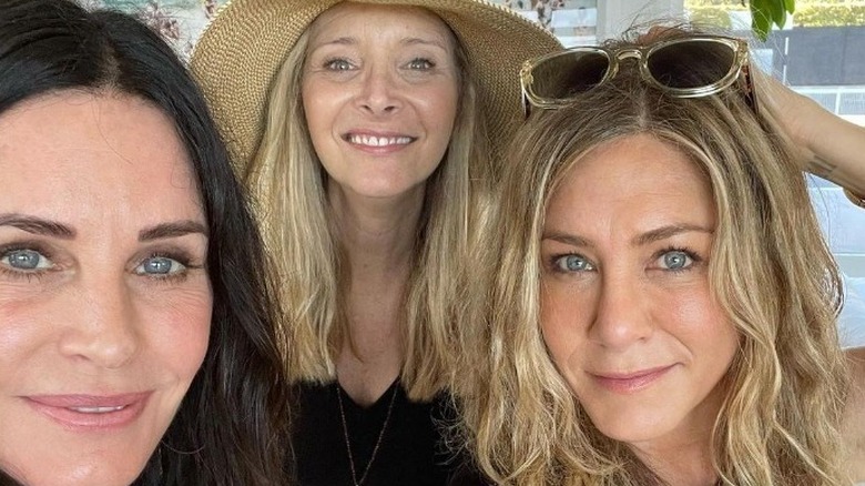 Courteney Cox, Jennifer Aniston, and Lisa Kudrow smile for the camera.