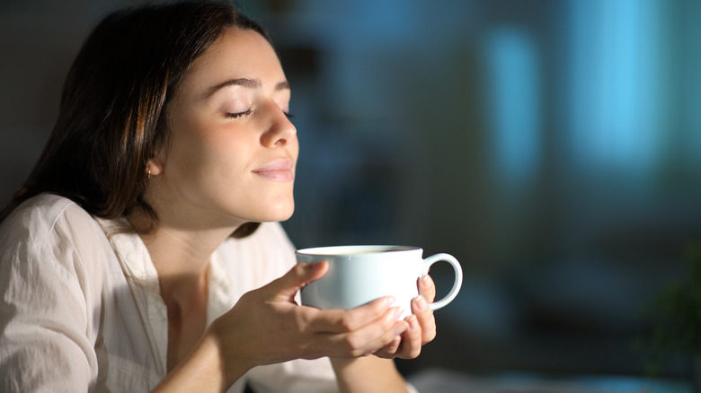 Woman smelling a cup of coffee