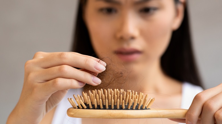 Woman removing hair from brush