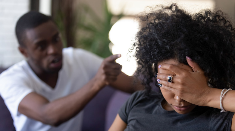 Man yelling at girlfriend while she looks frustrated