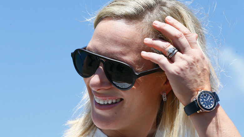 Zara Tindall smiling and wearing sunglasses showing her wedding ring