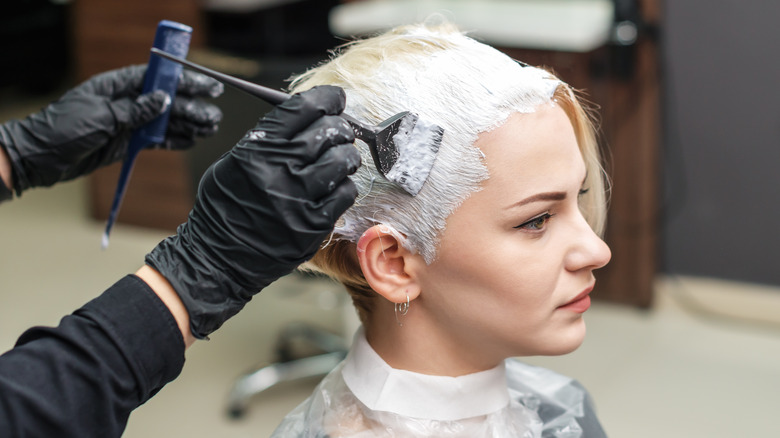 Stylist bleaching client's hair