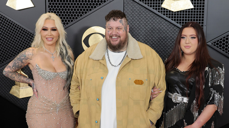 Bunnie XO, Jelly Roll, and Bailee Ann smiling on the Grammys red carpet