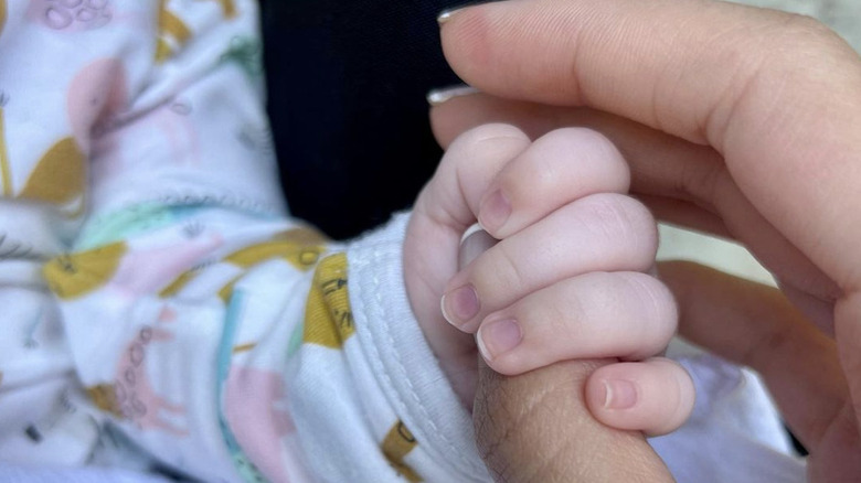 Noor Alfallah holding son Roman Pacino's hand