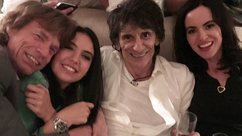 Mick Jagger, Noor Alfallah, Ronnie Wood, and Sally Wood smiling