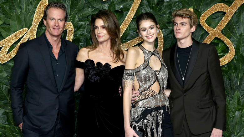 Rande Gerber posing in a black suit with his family