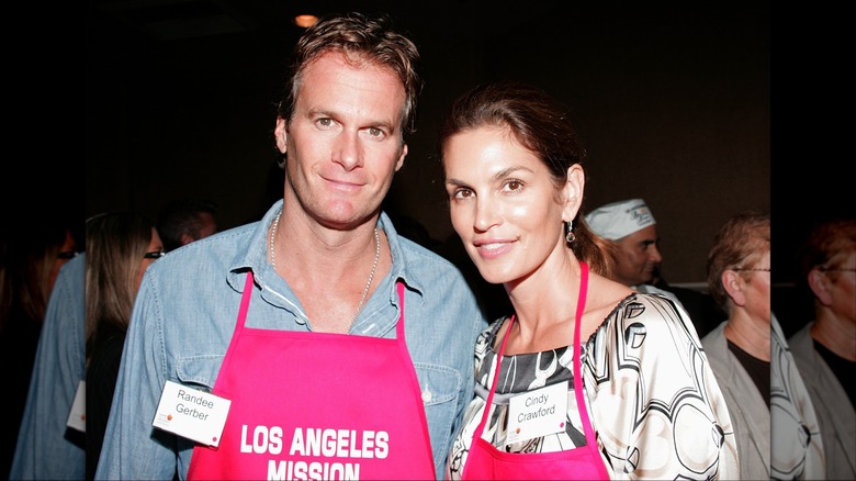 Rande Gerber posing with Cindy Crawford while serving food to the homeless