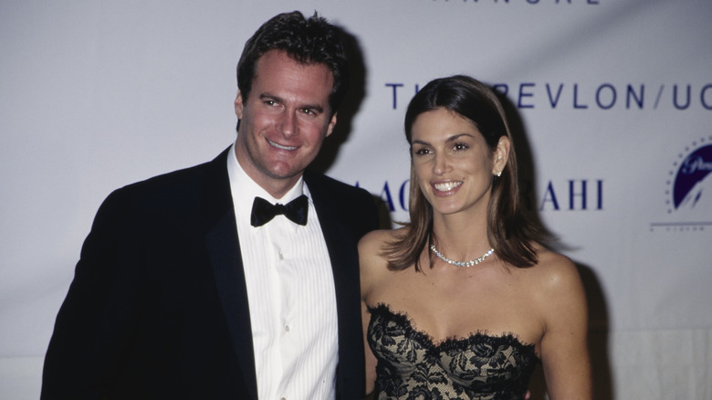 Rande Gerber posing in a tux and Cindy Crawford posing in a black lace dress