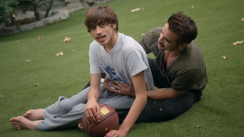 Colin Farrell and James Farrell sitting on the grass