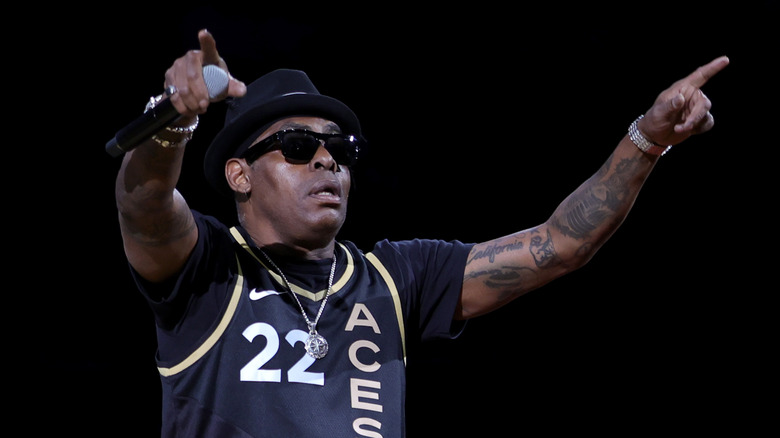 Coolio holds up his hands while performing onstage