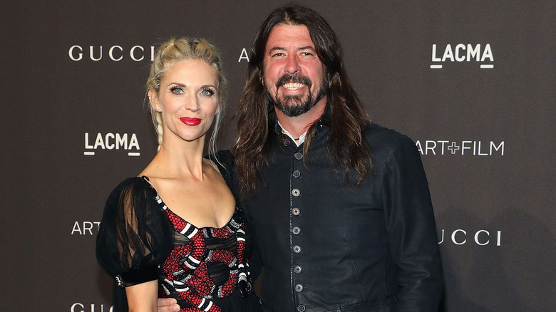 Jordyn Blum in black dress with snakes and Dave Grohl smiling in black jacket