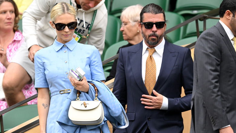 Jordyn Blum in blue dress and sunglasses and Dave Grohl in suit with sunglasses