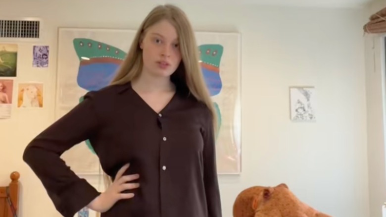 Vivian Jenna Wilson standing with hand on hip in black button up shirt with hair down