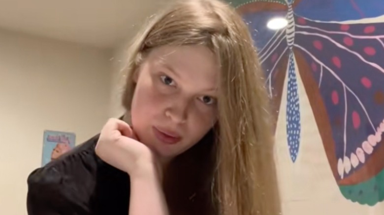 Close up of Vivian Jenna Wilson resting head on hand with long hair down in black shirt