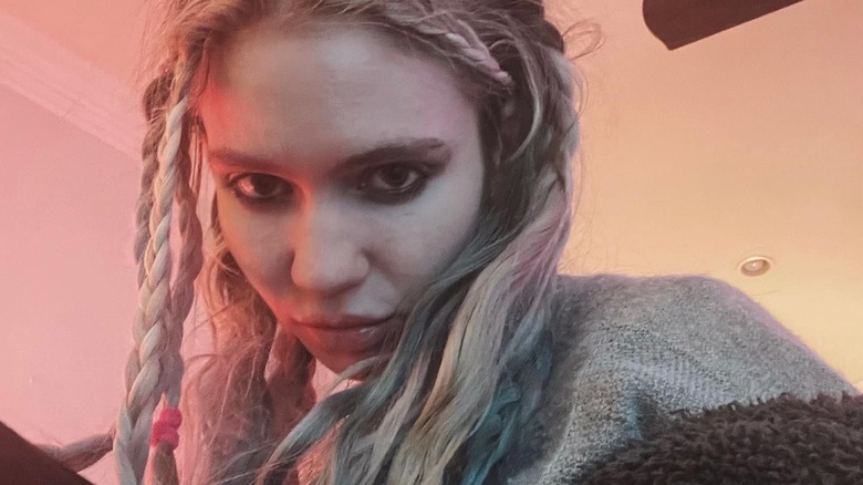 A closeup selfie of Grimes in messy braids