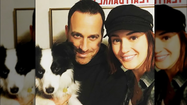 Ray Galletti and Katherine Barrell smiling with their dog