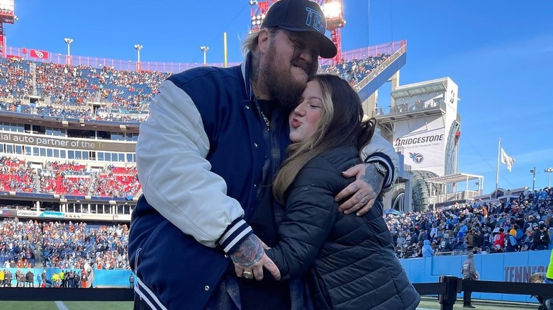 Jelly Roll and Bailee Ann DeFord hugging on football field