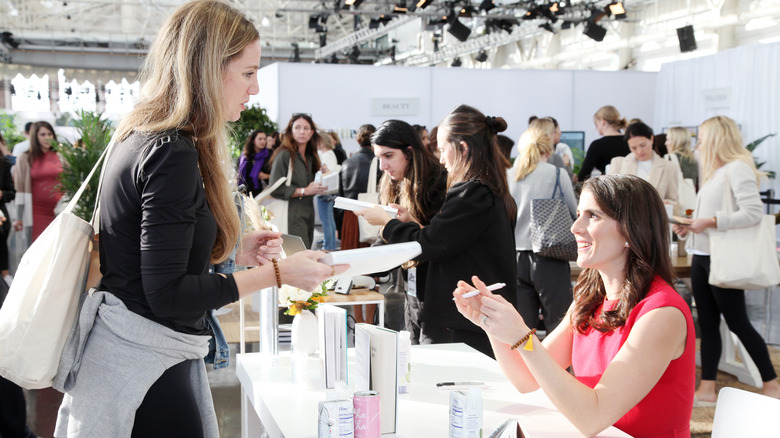 Tatiana Schlossberg talking to woman at her book signing