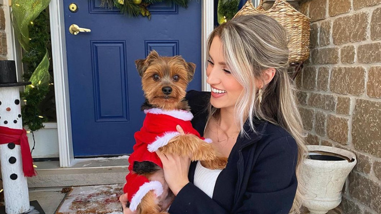 Kaity Biggar holding dog in Santa outfit