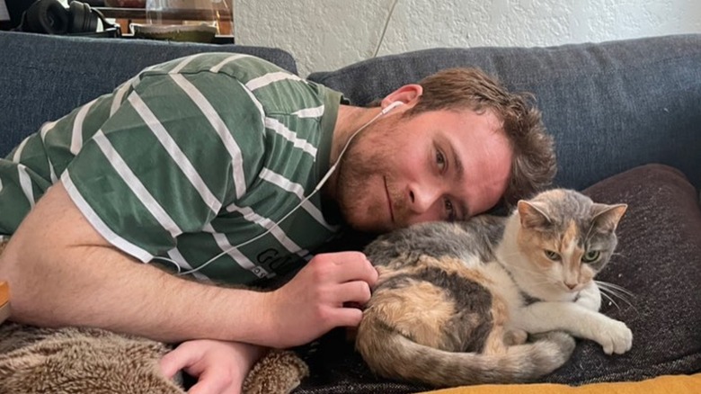 Cole Emhoff lying down on couch with cat