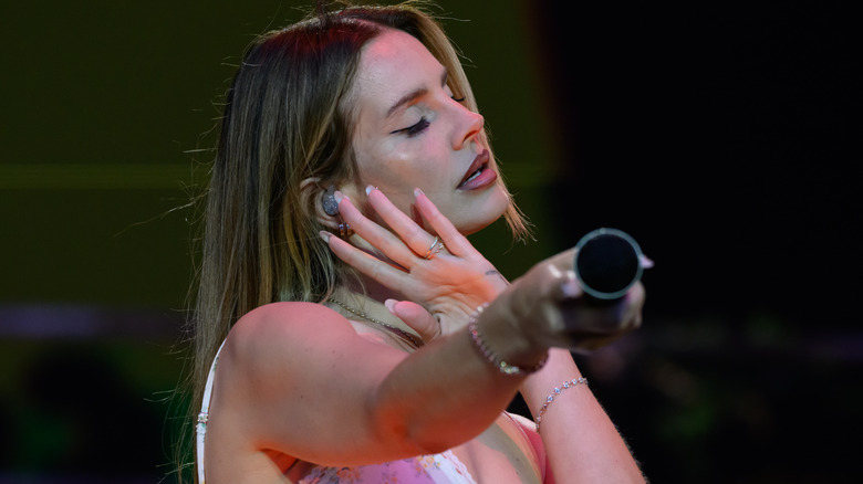 Lana Del Rey holding mic out to fans