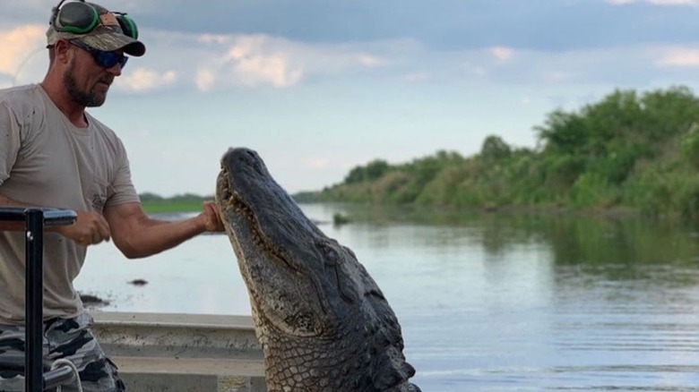 Jeremy Dufrene petting alligator