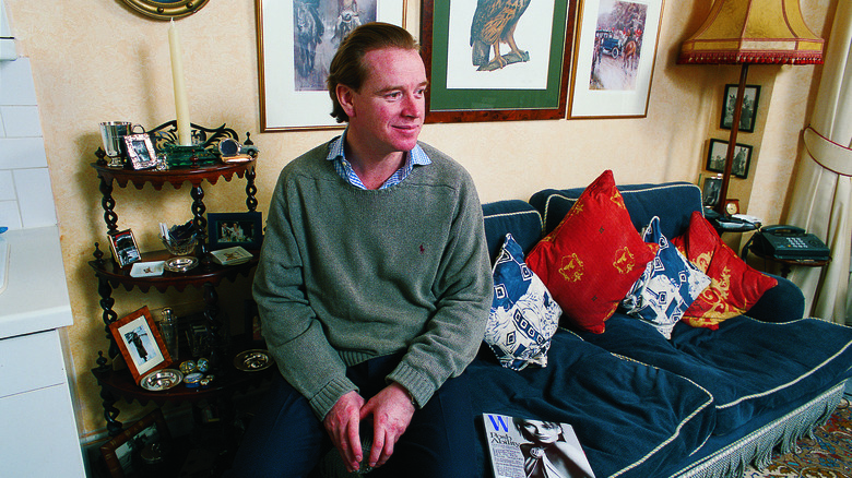 Major James Hewitt sitting on edge of couch