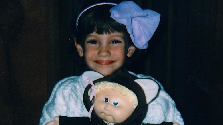 Emily Compagno as a child holding Cabbage Patch doll