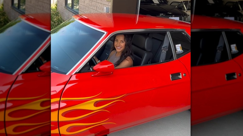 Emily Compagno smiling in orange Mustang