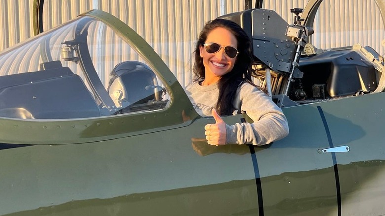 Emily Compagno smiling with a thumbs up in a fighter jet