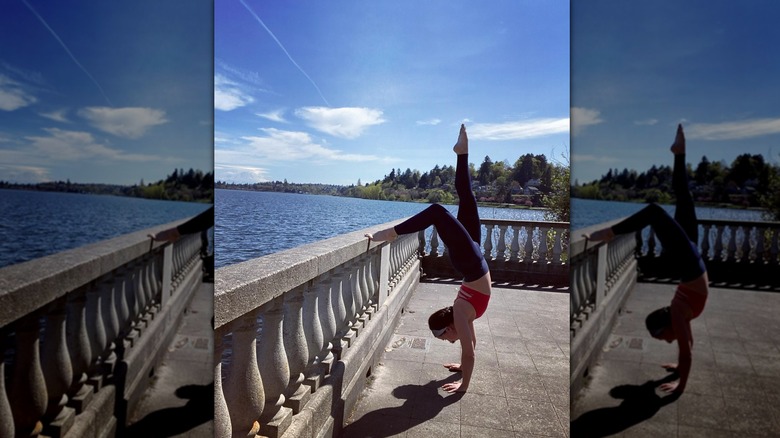 Emily Compagno doing a handstand next to water