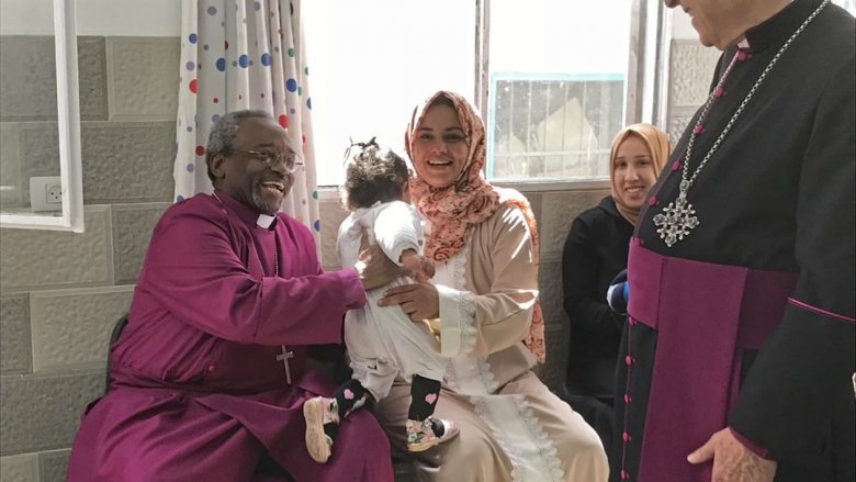 Reverend Michael Curry holding a baby