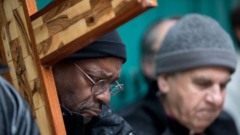 Reverend Michael Curry holding a big wooden cross