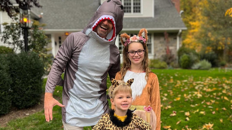 Rob Marciano posing in a shark costume with his children 