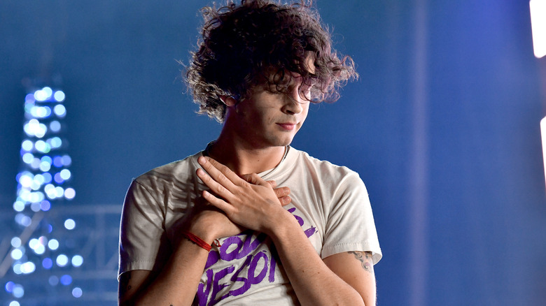 Matt Healy holding his hands over his heart