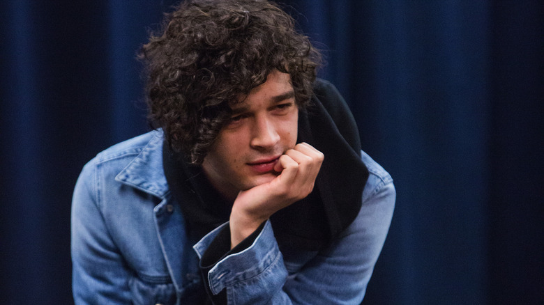 Matt Healy with his head in his hand