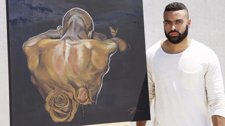 Justin Glaze standing next to a painting