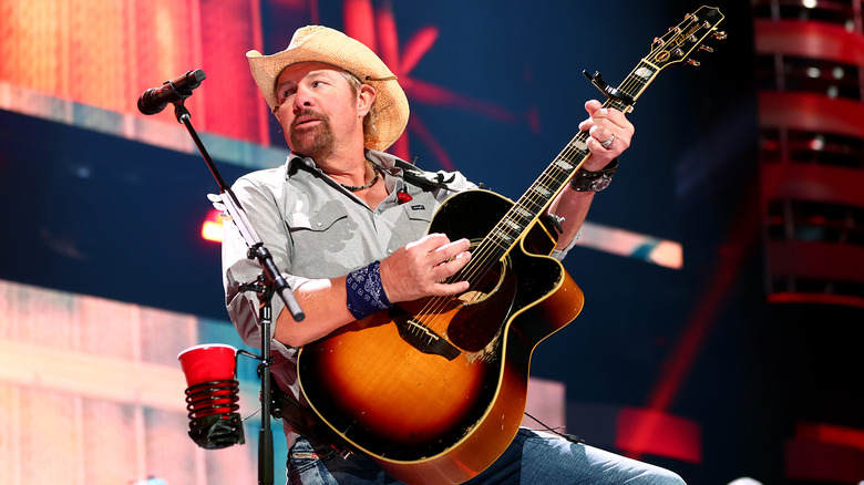 Toby Keith playing guitar on stage