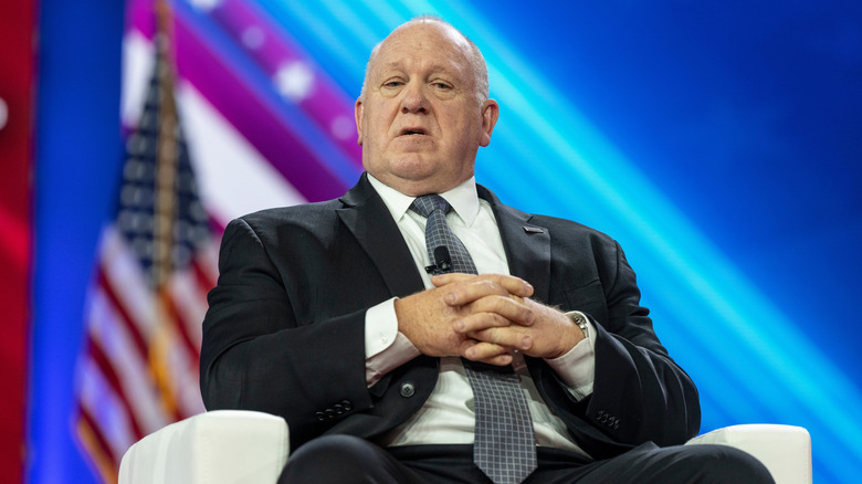 Tom Homan sitting on stage at a political event