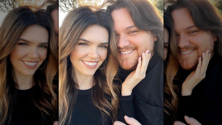 Andraia Allsop touching Wolfgang Van Halen's face as they smile to camera